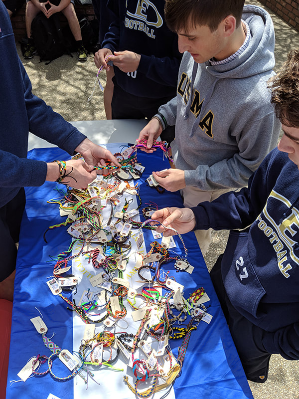 Students looking at Pulsera items for sale.