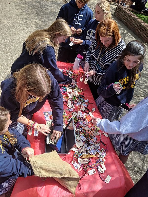 Students looking at Pulsera items for sale.
