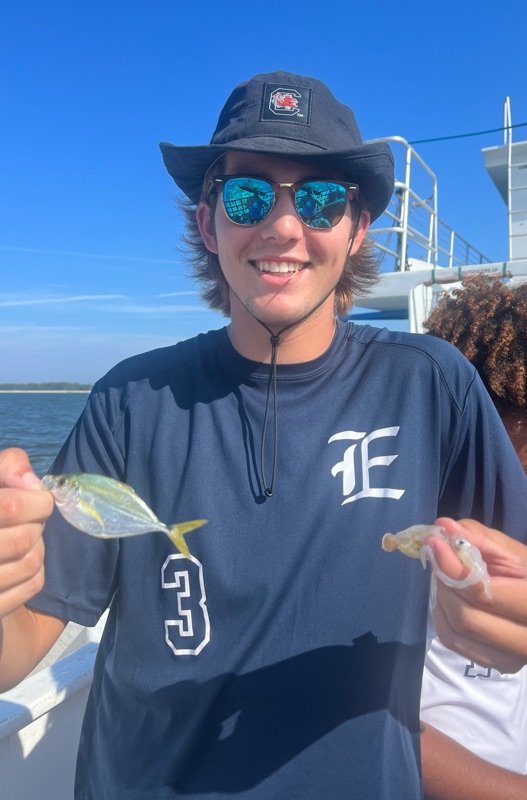 Student with fish on research vessel