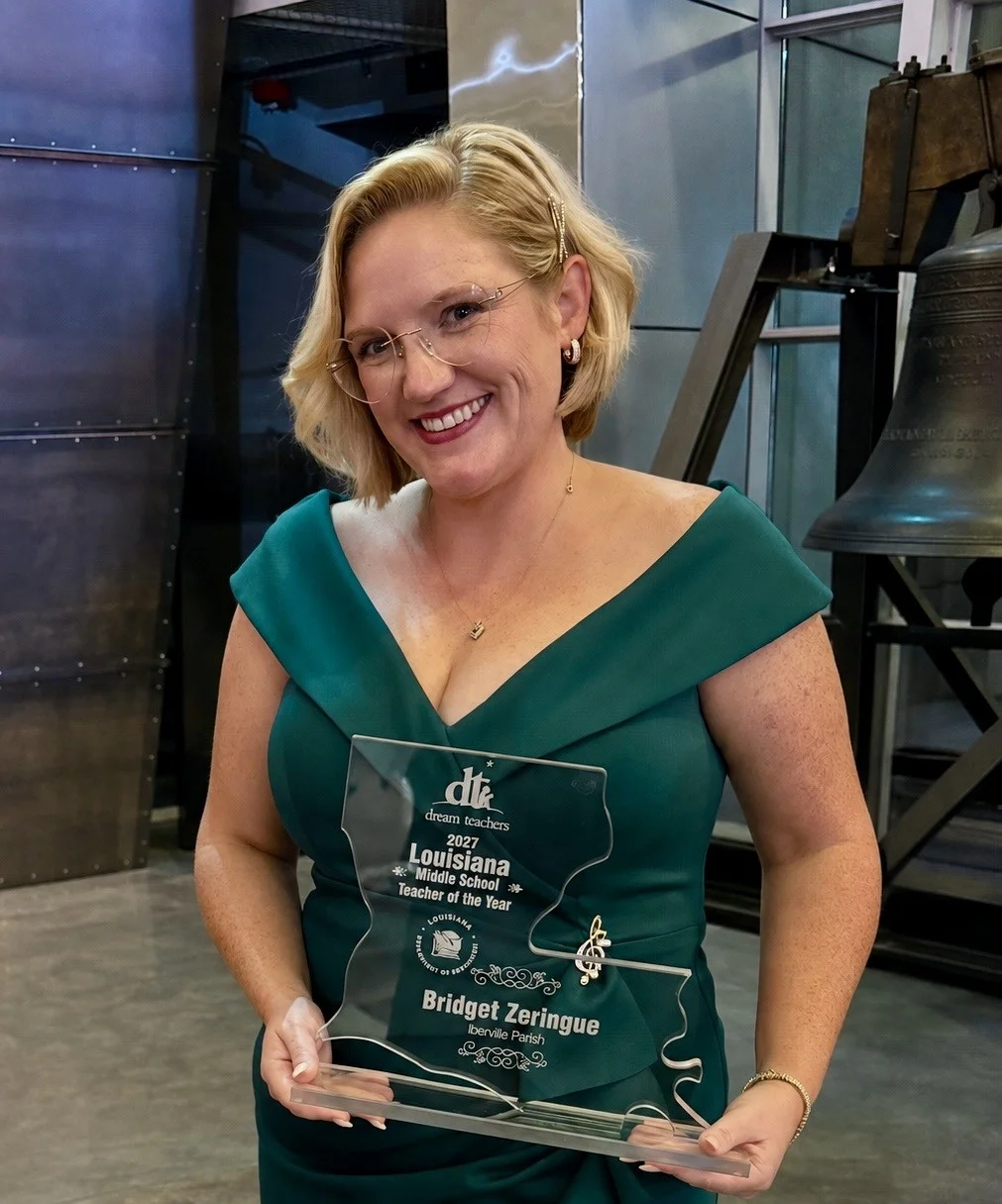 Smiling woman in a teal off-shoulder dress holding a glass award engraved 'Louisiana Middle School Teacher of the Year'.