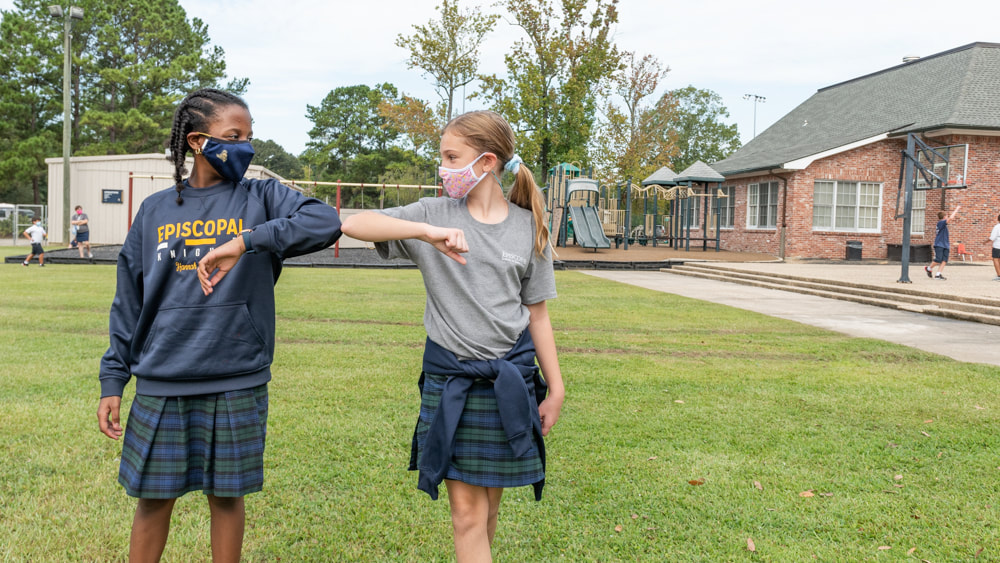 Students fist bump on campus.