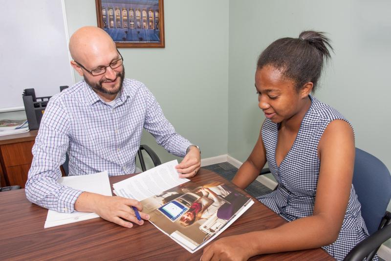 College Counselor Helping Student at a Desk